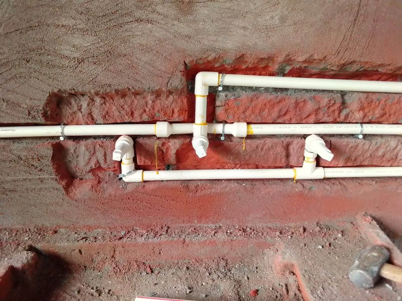 Water pipe connections installed along a brick wall from the business Google listing